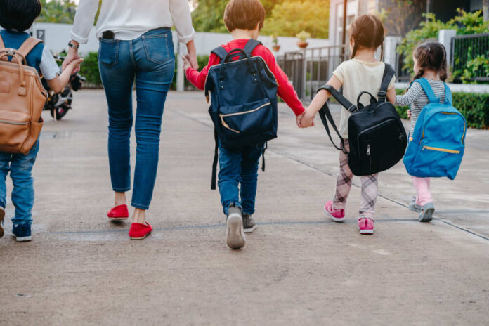 Mother,And,Pupil,And,Kids,Holding,Hands,Going,To,School