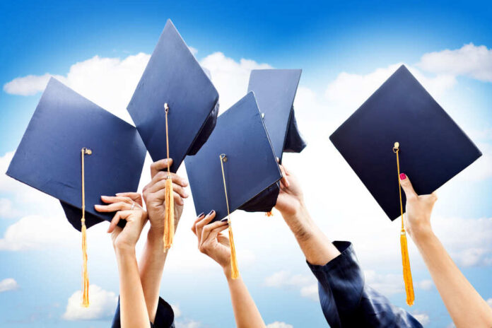 Unrecognizable,Group,Of,People,Throwing,Graduations,Hats,In,The,Air