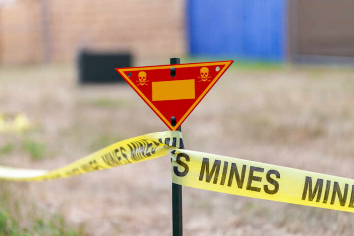 Land,Mine,Warning,Sign,Stands,On,Grass