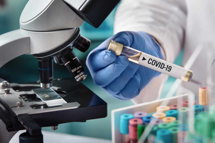 Microbiologist,With,A,Tube,Of,Biological,Sample,Contaminated,By,Coronavirus