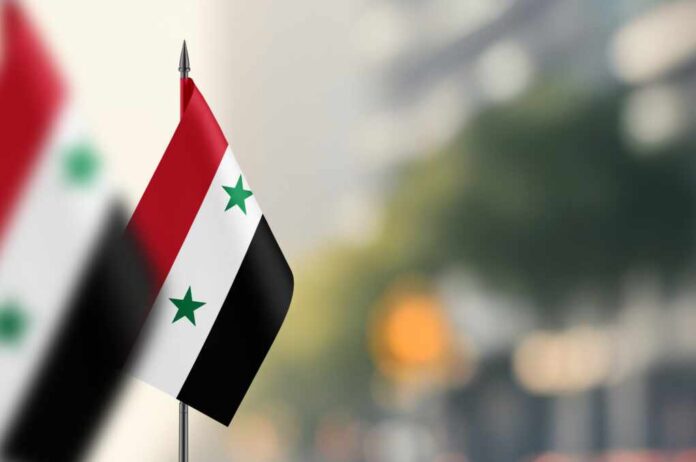 Small,Flags,Of,Syria,On,A,Blurred,Background