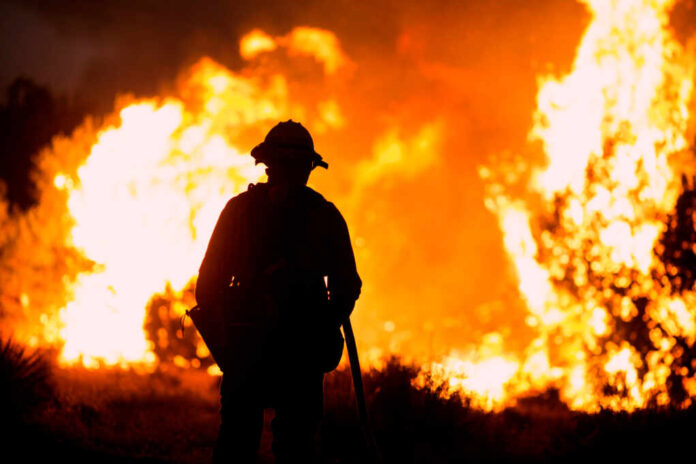 A,Firefighter,Watches,As,The,Bobcat,Fire,Burns,In,Juniper