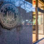 FBI emblem displayed on the exterior of a government building at night