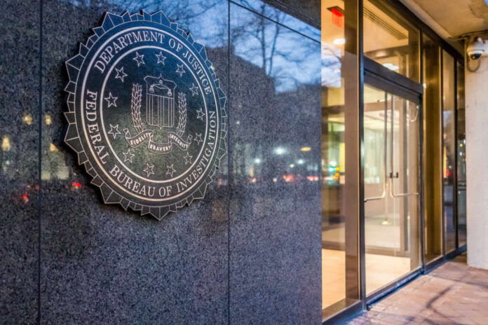 FBI emblem displayed on the exterior of a government building at night