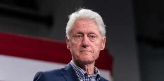 Former president speaking at a campaign rally with an American flag backdrop