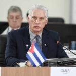 Cuban representative at a political meeting with a flag in front