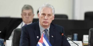Cuban representative at a political meeting with a flag in front
