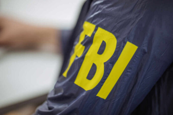 shutterstock_612694196.jpg Close-up of an FBI agents jacket with yellow lettering