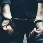 A person in handcuffs with their hands behind their back