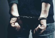 A person in handcuffs with their hands behind their back