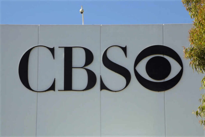 CBS logo displayed on a white wall with a blue sky background