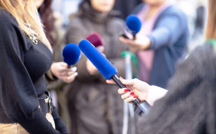 shutterstock2396944669jpg Reporters holding microphones during an interview