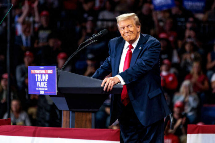 A speaker at a political rally smiling while addressing the audience