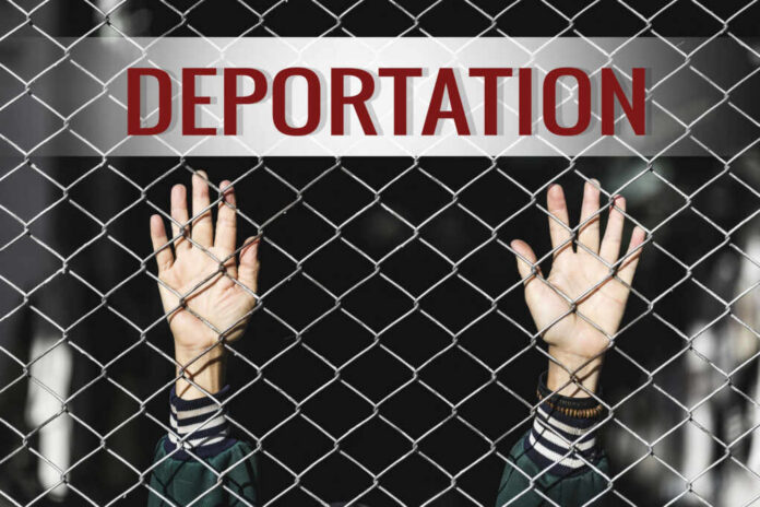 Hands reaching through a metal fence with the word DEPORTATION above