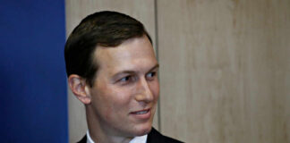 A man in a suit smiling in a professional setting