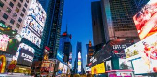 Crowd of people in Times Square surrounded by bright advertisements and buildings