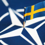 Small Swedish flag on a NATO emblem background