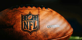 Close-up of an official NFL football with team logos and leather texture