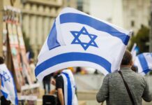 Person holding an Israeli flag at a public demonstration