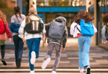Group of children walking together with backpacks in an urban area