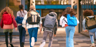 Group of children walking together with backpacks in an urban area