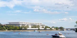 A scenic view of a river with boats and a modern building in the background