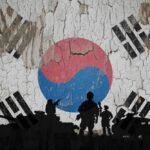 Silhouettes of soldiers in front of the South Korean flag on a cracked wall