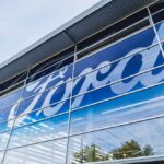 Exterior view of a Ford dealership with a large logo on the glass
