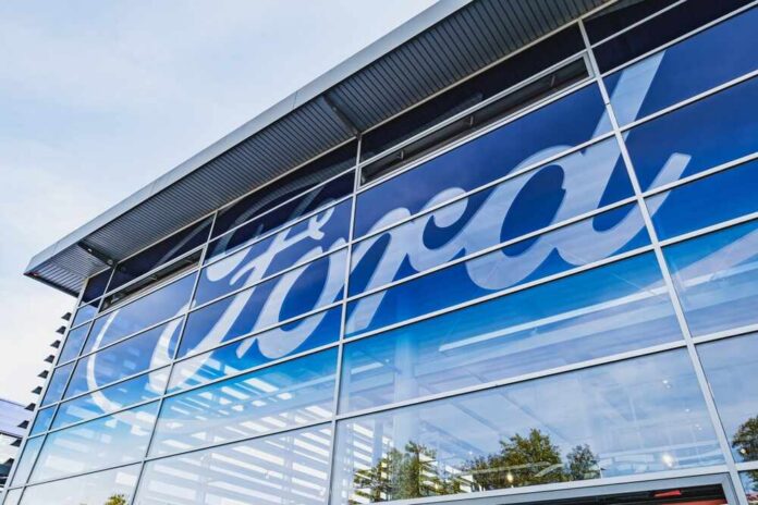 Exterior view of a Ford dealership with a large logo on the glass