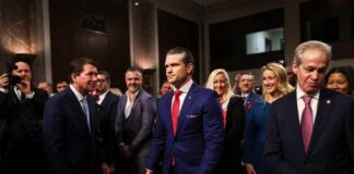 A group of individuals in formal attire at a congressional hearing