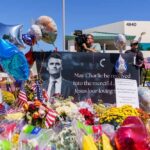 A memorial site with flowers, balloons, and a large photo honoring Charlie