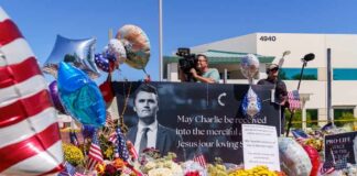 A memorial site with flowers, balloons, and a large photo honoring Charlie