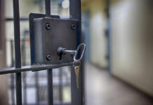 Hollywood Shock: Perry’s Supplier Gets 15 Years Close-up of a locked jail cell door with a key inserted
