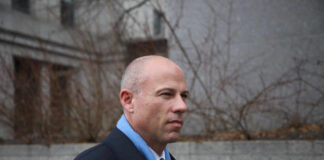 Man in business attire walking outdoors with a serious expression