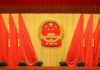 Backdrop featuring the Chinese national emblem with red curtains