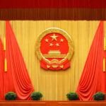 Backdrop featuring the Chinese national emblem with red curtains