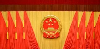 China’s Power Play: Allies Left in the Dust Backdrop featuring the Chinese national emblem with red curtains