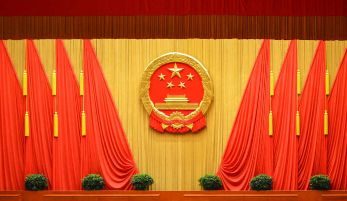 Backdrop featuring the Chinese national emblem with red curtains