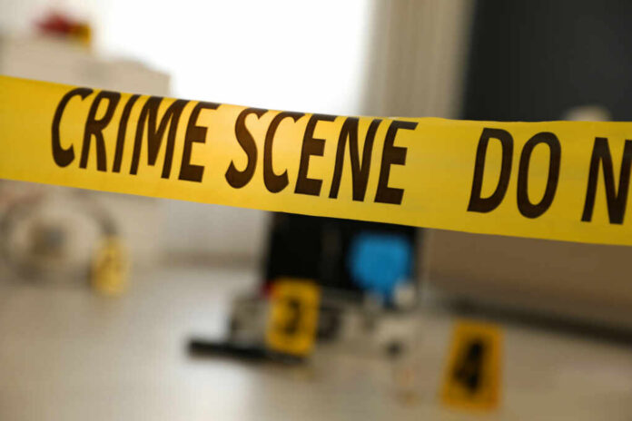 Yellow crime scene tape with evidence markers in a room