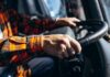 Close-up of hands gripping a steering wheel inside a vehicle