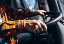 Close-up of hands gripping a steering wheel inside a vehicle