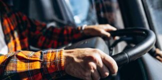 Close-up of hands gripping a steering wheel inside a vehicle