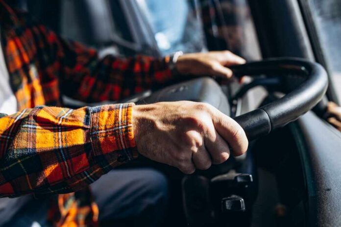 Close-up of hands gripping a steering wheel inside a vehicle