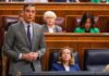 A politician delivering a speech in a government assembly with attentive audience members