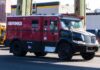 A red and black Brinks armored truck parked on a city street