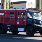 A red and black Brinks armored truck parked on a city street