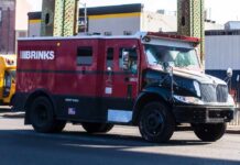 A red and black Brinks armored truck parked on a city street