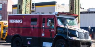 A red and black Brinks armored truck parked on a city street