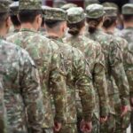 Line of soldiers in camouflage uniforms standing in formation