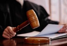 A judges gavel poised above a wooden block with a document in the background